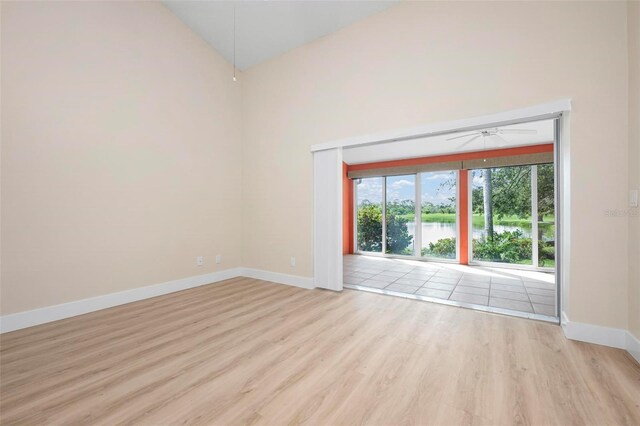 4472 Calle Serena, Sarasota, FL 34238 - unfurnished room featuring ceiling fan, wood finished floors, baseboards, high vaulted ceiling, and a water view