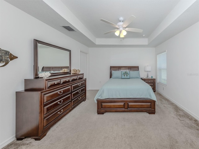 12682 Shimmering Oak Cir, Venice, FL 34293 - bedroom featuring a raised ceiling, light carpet, and a ceiling fan