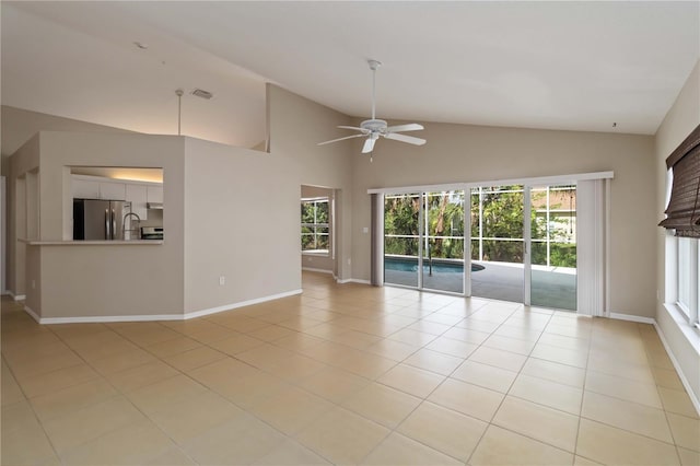 2662 6th Ct E, Ellenton, FL 34222 - unfurnished living room featuring healthy amount of natural light, a ceiling fan, baseboards, light tile patterned floors, and high vaulted ceiling