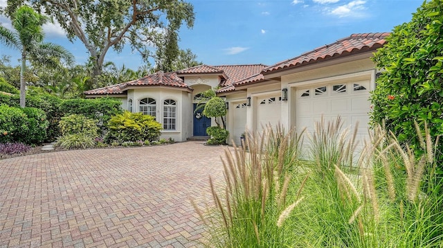 1864 Goldenrod St, Sarasota, FL 34239 - mediterranean / spanish-style home with a tiled roof, stucco siding, decorative driveway, and a garage