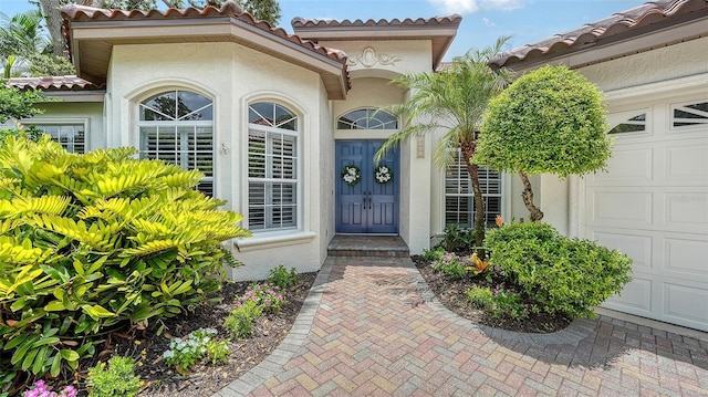 1864 Goldenrod St, Sarasota, FL 34239 - view of exterior entry with a tile roof, stucco siding, and a garage