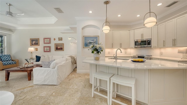 1864 Goldenrod St, Sarasota, FL 34239 - kitchen featuring stainless steel microwave, ornamental molding, stove, open floor plan, and decorative backsplash