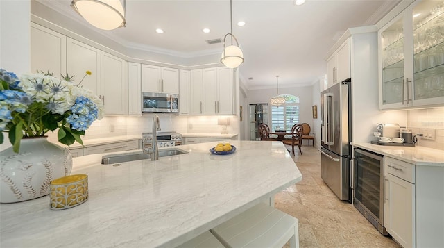 1864 Goldenrod St, Sarasota, FL 34239 - kitchen with stainless steel appliances, wine cooler, ornamental molding, backsplash, and light stone countertops