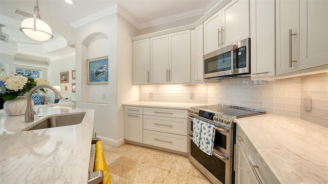 1864 Goldenrod St, Sarasota, FL 34239 - kitchen with stainless steel appliances, crown molding, backsplash, white cabinetry, and light stone counters