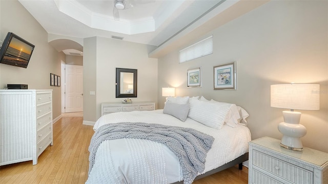 1864 Goldenrod St, Sarasota, FL 34239 - bedroom featuring a tray ceiling, arched walkways, light wood finished floors, and ceiling fan