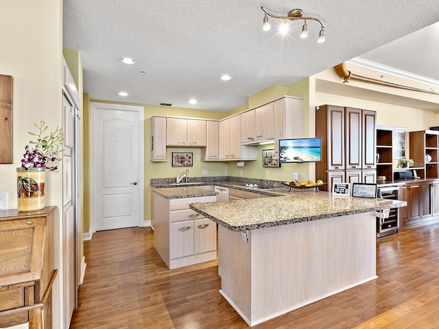 1233 N Gulfstream Ave Unit 401, Sarasota, FL 34236 - kitchen with wine cooler, a sink, a peninsula, light wood-style floors, and a textured ceiling