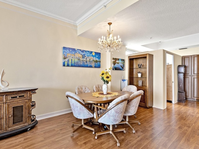 1233 N Gulfstream Ave Unit 401, Sarasota, FL 34236 - dining space with ornamental molding, wood finished floors, a chandelier, a textured ceiling, and baseboards
