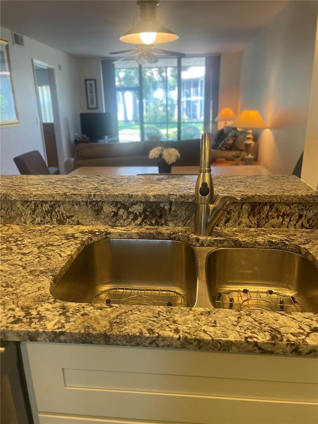 4520 47th Ave W Unit 103, Bradenton, FL 34210 - kitchen view of a sink, a ceiling fan, and dark stone counters