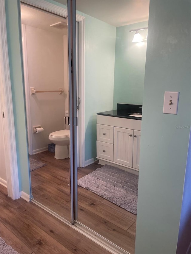 4520 47th Ave W Unit 103, Bradenton, FL 34210 - bathroom with wood finished floors, toilet, vanity, and baseboards