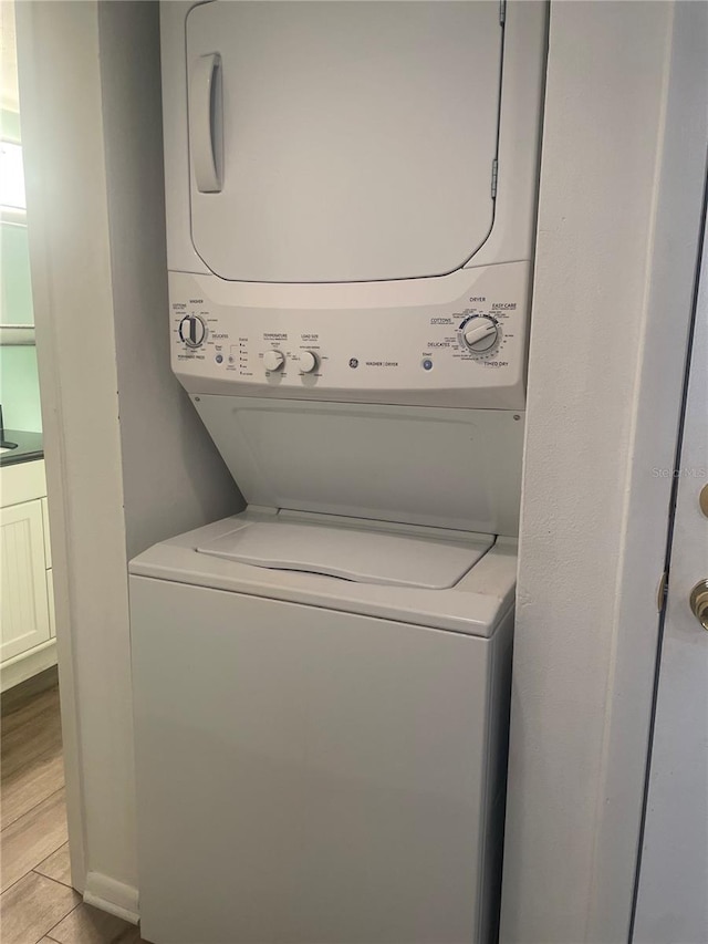 4520 47th Ave W Unit 103, Bradenton, FL 34210 - laundry area with stacked washer and clothes dryer and light wood-style flooring