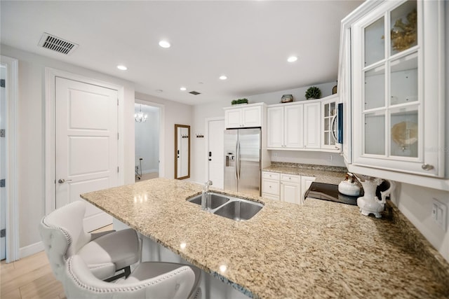 525 N Orange Ave Unit 302, Sarasota, FL 34236 - kitchen featuring appliances with stainless steel finishes, a sink, light stone countertops, a peninsula, and a kitchen bar