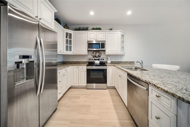 525 N Orange Ave Unit 302, Sarasota, FL 34236 - kitchen with stainless steel appliances, a sink, light stone countertops, recessed lighting, and glass insert cabinets