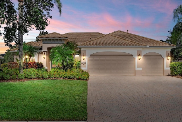 6528 Coopers Hawk Ct, Lakewood Ranch, FL 34202 - mediterranean / spanish-style home with a garage, decorative driveway, stucco siding, a front lawn, and a tile roof