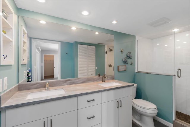 2729 N Beach Rd Unit 212, Englewood, FL 34223 - bathroom featuring double vanity, a closet, a shower stall, toilet, and recessed lighting