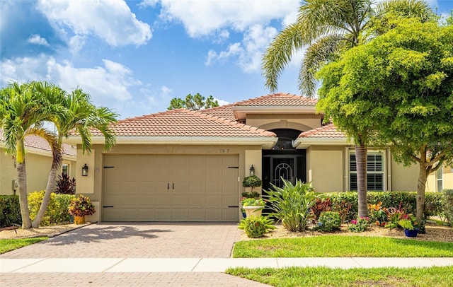 11625 Parrotfish St, Venice, FL 34292 - mediterranean / spanish-style house featuring stucco siding, an attached garage, a tiled roof, and decorative driveway