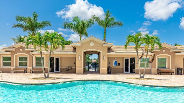 11625 Parrotfish St, Venice, FL 34292 - back of house featuring stucco siding, french doors, and an outdoor pool