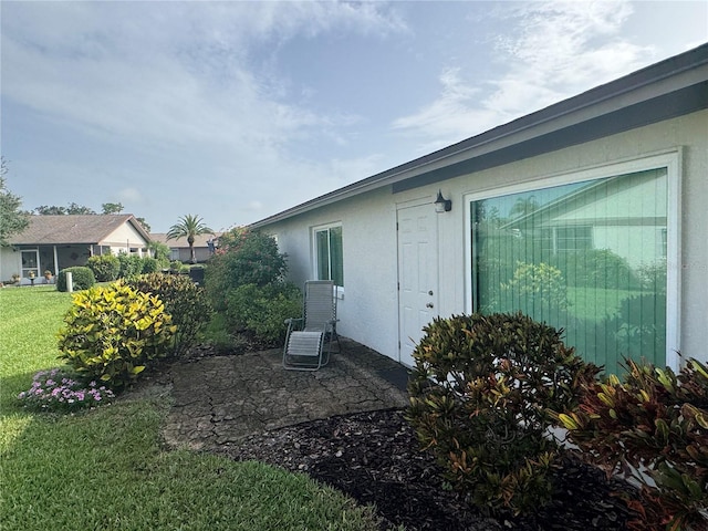 3752 Collins St Unit 508, Sarasota, FL 34232 - view of side of home featuring a lawn, stucco siding, and a patio area