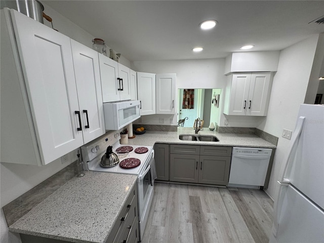 3752 Collins St Unit 508, Sarasota, FL 34232 - kitchen with white appliances, a sink, light wood-type flooring, white cabinets, and recessed lighting