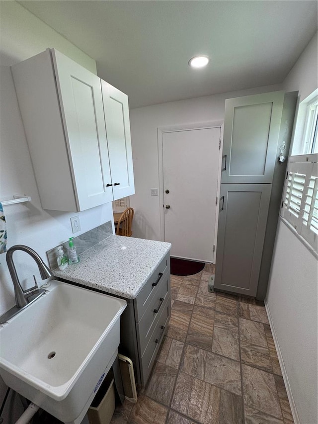 3752 Collins St Unit 508, Sarasota, FL 34232 - washroom with baseboards, cabinet space, dark stone finish flooring, and recessed lighting