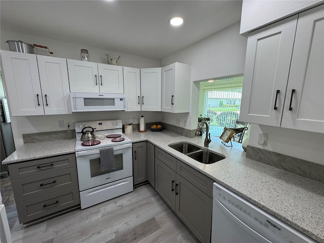 3752 Collins St Unit 508, Sarasota, FL 34232 - kitchen featuring white appliances, a sink, gray cabinets, light wood-style floors, and white cabinetry