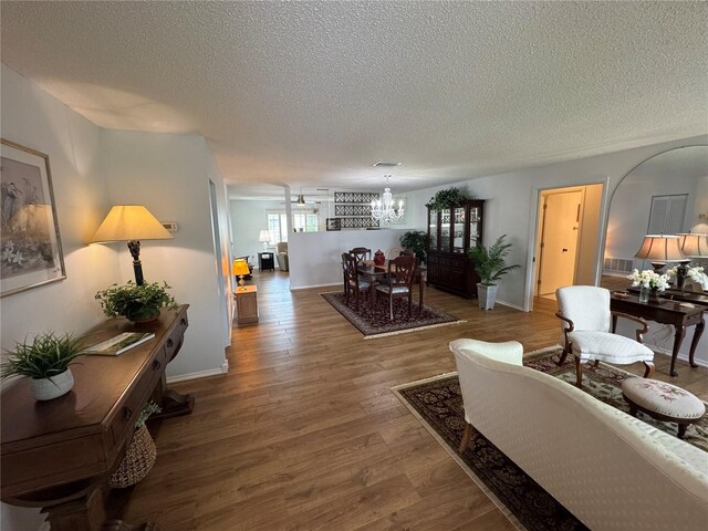 3752 Collins St Unit 508, Sarasota, FL 34232 - living area featuring a chandelier, a textured ceiling, wood finished floors, and baseboards
