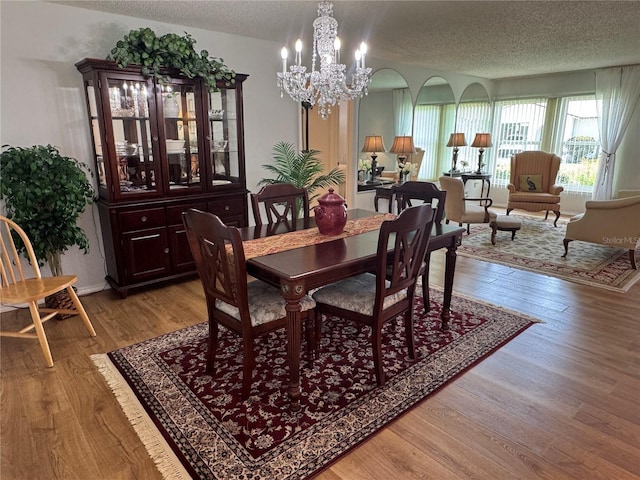 3752 Collins St Unit 508, Sarasota, FL 34232 - dining area with a textured ceiling, light wood-style floors, and a chandelier