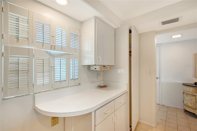 1350 N Portofino Dr Unit 402, Sarasota, FL 34242 - kitchen with white cabinetry, light tile patterned floors, and light countertops