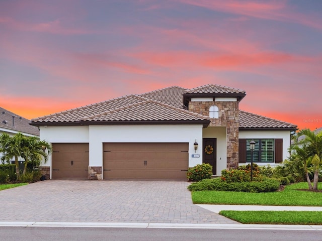 13606 Deep Blue Pl, Bradenton, FL 34211 - mediterranean / spanish-style house featuring stone siding, a tiled roof, a garage, and stucco siding