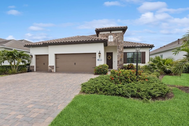13606 Deep Blue Pl, Bradenton, FL 34211 - mediterranean / spanish-style house featuring stone siding, stucco siding, decorative driveway, a garage, and a tiled roof