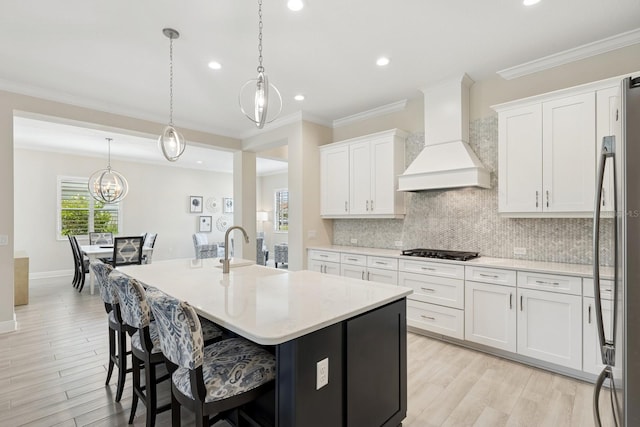 13606 Deep Blue Pl, Bradenton, FL 34211 - kitchen featuring custom range hood, black gas cooktop, white cabinetry, a sink, and recessed lighting