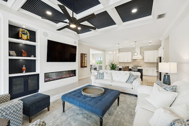 13606 Deep Blue Pl, Bradenton, FL 34211 - living room with coffered ceiling, crown molding, a glass covered fireplace, beam ceiling, and light wood-type flooring