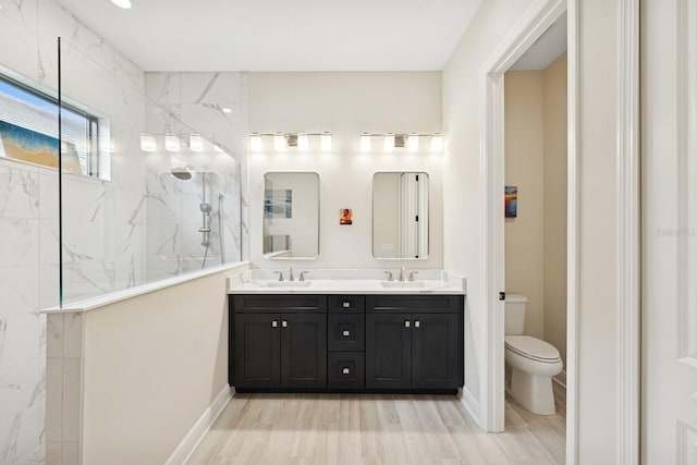 13606 Deep Blue Pl, Bradenton, FL 34211 - full bathroom with double vanity, walk in shower, toilet, wood finished floors, and baseboards