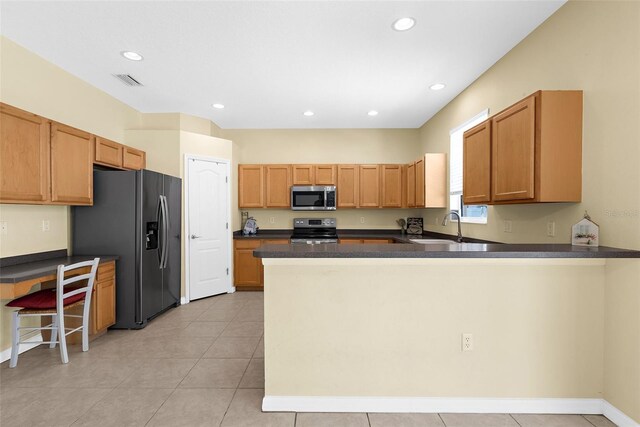 5981 Willows Bridge Loop, Ellenton, FL 34222 - kitchen featuring appliances with stainless steel finishes, a peninsula, a sink, dark countertops, and recessed lighting