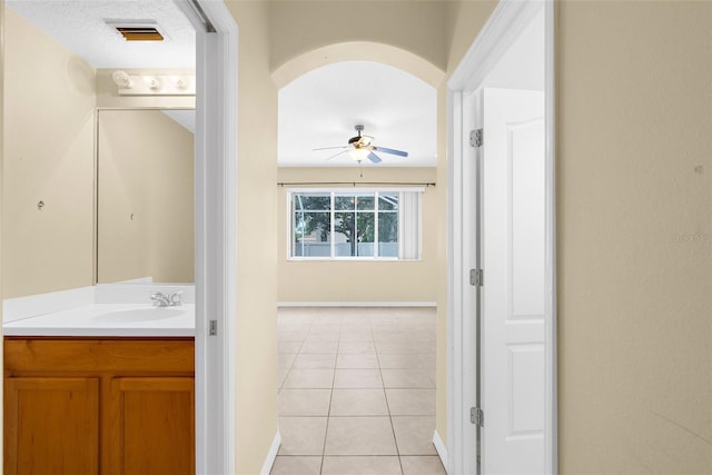 5981 Willows Bridge Loop, Ellenton, FL 34222 - hall featuring a sink, baseboards, light tile patterned floors, and arched walkways