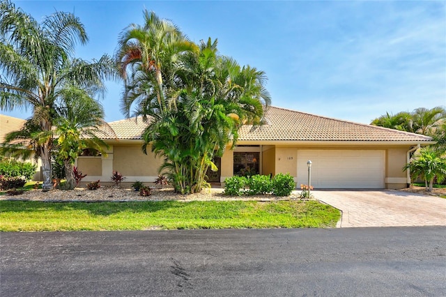 105 Inlets Blvd Unit 105, Nokomis, FL 34275 - view of front of property with a tile roof, a garage, stucco siding, and driveway