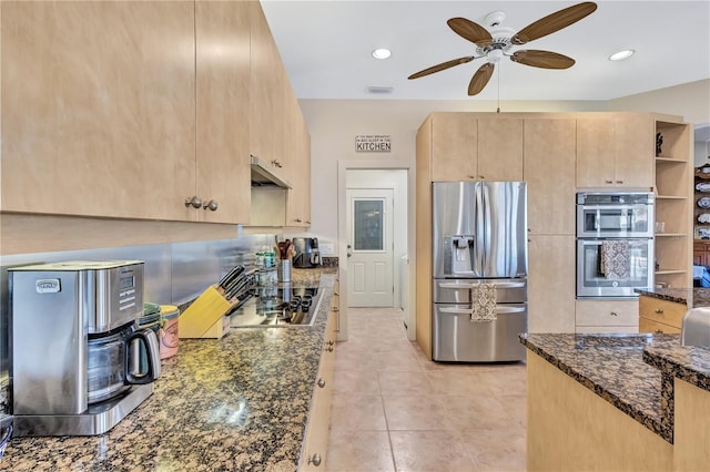 105 Inlets Blvd Unit 105, Nokomis, FL 34275 - kitchen with stainless steel appliances, light brown cabinetry, a ceiling fan, dark stone countertops, and under cabinet range hood