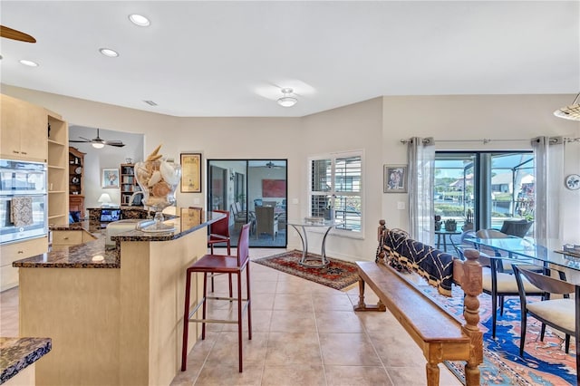 105 Inlets Blvd Unit 105, Nokomis, FL 34275 - kitchen featuring a ceiling fan, double oven, dark stone countertops, light tile patterned flooring, and recessed lighting