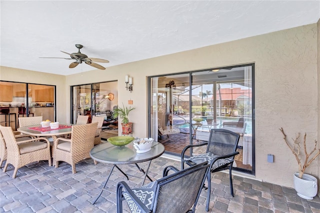 105 Inlets Blvd Unit 105, Nokomis, FL 34275 - dining room featuring a ceiling fan, stone finish flooring, a sunroom, and a textured wall