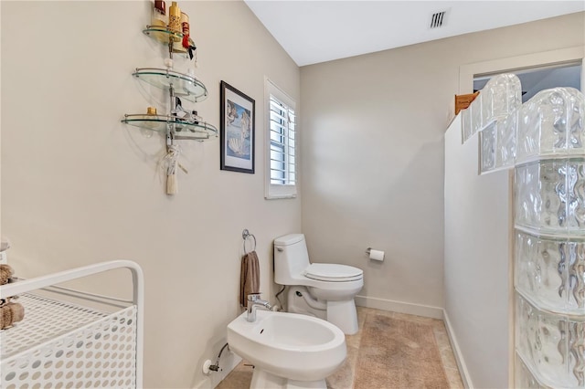 105 Inlets Blvd Unit 105, Nokomis, FL 34275 - bathroom with a bidet, toilet, baseboards, and tile patterned floors
