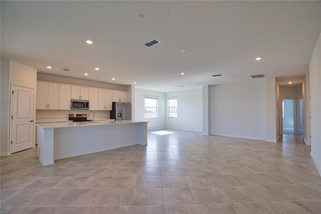 17715 Boracay Ct Unit 202, Venice, FL 34293 - kitchen with appliances with stainless steel finishes, open floor plan, light countertops, an island with sink, and white cabinetry
