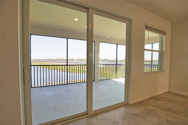 17715 Boracay Ct Unit 202, Venice, FL 34293 - doorway with plenty of natural light, a water view, baseboards, and tile patterned flooring