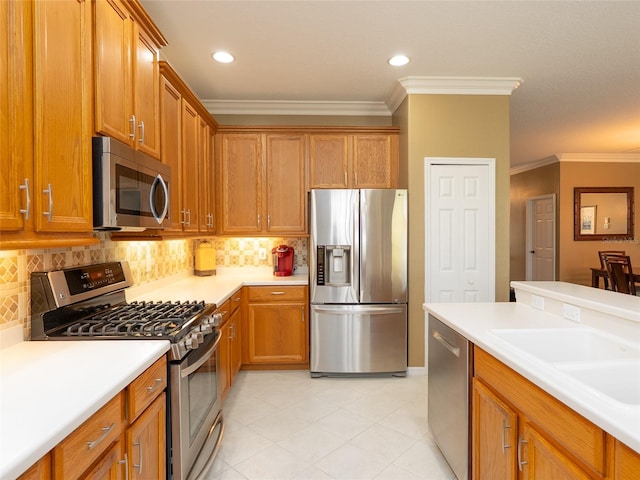 8078 Stirling Falls Cir, Sarasota, FL 34243 - kitchen with appliances with stainless steel finishes, crown molding, light countertops, brown cabinets, and decorative backsplash