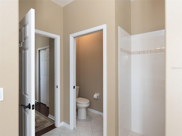 8078 Stirling Falls Cir, Sarasota, FL 34243 - bathroom featuring toilet, a tile shower, tile patterned flooring, and baseboards