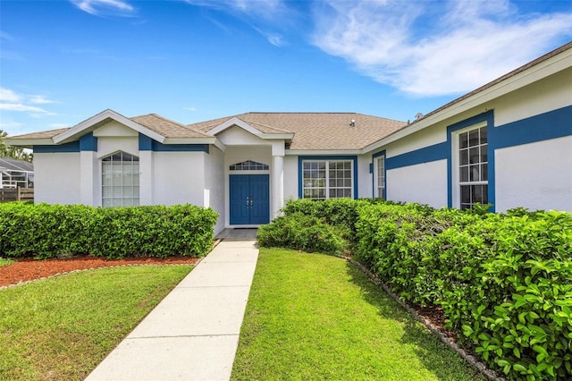 9402 71st Ave E, Palmetto, FL 34221 - view of front of home featuring stucco siding, a front yard, and a shingled roof