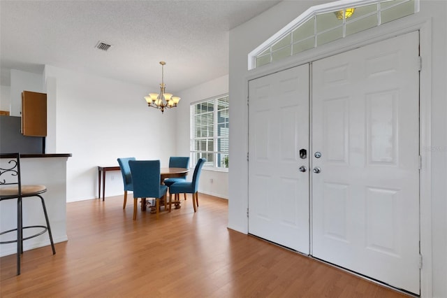 9402 71st Ave E, Palmetto, FL 34221 - entrance foyer featuring a chandelier, light wood-type flooring, baseboards, and a textured ceiling