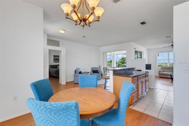 9402 71st Ave E, Palmetto, FL 34221 - dining room featuring a chandelier, light wood-style flooring, a ceiling fan, and baseboards