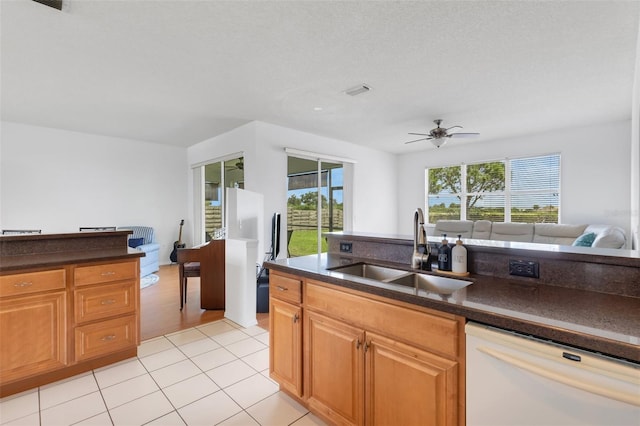 9402 71st Ave E, Palmetto, FL 34221 - kitchen with white dishwasher, a sink, dark countertops, open floor plan, and light tile patterned flooring
