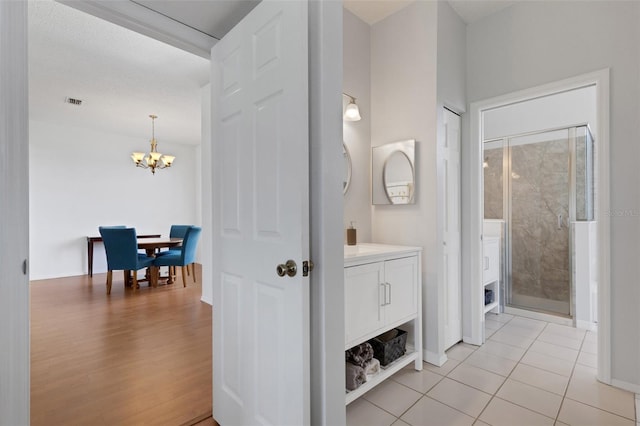 9402 71st Ave E, Palmetto, FL 34221 - full bathroom featuring vanity, a chandelier, a shower stall, and tile patterned floors