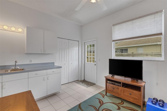 9402 71st Ave E, Palmetto, FL 34221 - kitchen with a sink, white cabinets, ceiling fan, and light tile patterned floors