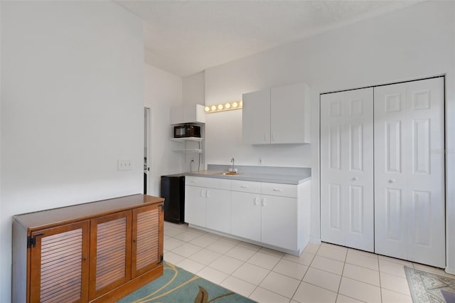 9402 71st Ave E, Palmetto, FL 34221 - kitchen featuring white cabinets, light countertops, light tile patterned flooring, and a sink